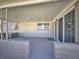 Covered front porch featuring brick accents and a view of the front yard and neighborhood at 18 Silk Oaks Dr, Ormond Beach, FL 32176