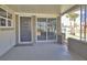 The covered front porch provides ample space and features a modern front door and a screened-in opening to the side yard at 18 Silk Oaks Dr, Ormond Beach, FL 32176