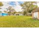 Spacious backyard featuring a grassy area, mature trees, shed and firepit at 254 Tanner St, New Smyrna Beach, FL 32168