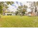 Large backyard featuring mature trees, shed, firepit and grassy space at 254 Tanner St, New Smyrna Beach, FL 32168