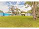 Expansive backyard featuring a large grassy area, mature trees, and a shed at 254 Tanner St, New Smyrna Beach, FL 32168