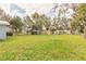 Expansive backyard with mature trees and view of the rear of the house at 254 Tanner St, New Smyrna Beach, FL 32168