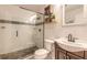 Updated bathroom with sleek glass shower, stone floor, modern fixtures, and decorative shelving at 254 Tanner St, New Smyrna Beach, FL 32168