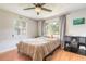 Bright bedroom featuring a ceiling fan, large windows with curtains, and laminate wood flooring at 254 Tanner St, New Smyrna Beach, FL 32168