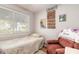 Cozy bedroom with a comfortable armchair, natural light from the window, and decorative wall hangings at 254 Tanner St, New Smyrna Beach, FL 32168