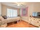 Bedroom with wood floors, ceiling fan, and a large window providing natural light at 254 Tanner St, New Smyrna Beach, FL 32168