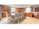 Well-lit kitchen featuring oak cabinets, a kitchen island, and a cozy breakfast bar area at 254 Tanner St, New Smyrna Beach, FL 32168