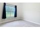 Bedroom with large window overlooking backyard and neutral carpet at 2590 Erena Dr, New Smyrna Beach, FL 32168