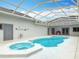 Screened-in pool and spa area featuring a unique shape, white decking, and clear blue water at 2590 Erena Dr, New Smyrna Beach, FL 32168