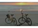 Bicycles parked at the beach in front of an ocean sunrise. Enjoy the sunrise on two wheels at 26 Birdie Dr, New Smyrna Beach, FL 32168