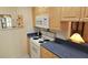 Kitchen with light wood cabinets, a white electric stove, and dark countertops at 26 Birdie Dr, New Smyrna Beach, FL 32168