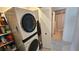 Efficient laundry area with stacked washer/dryer unit and storage, adjacent to bathroom for convenience at 26 Birdie Dr, New Smyrna Beach, FL 32168