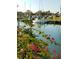 Picturesque view of a marina with boats docked along the water, framed by vibrant pink bougainvillea at 26 Birdie Dr, New Smyrna Beach, FL 32168