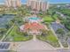 Aerial view showcasing a clubhouse, pool, and tennis courts, surrounded by beautiful landscapes at 263 Minorca Beach Way # 801, New Smyrna Beach, FL 32169