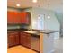 Kitchen featuring wood cabinetry, a stainless steel dishwasher, and tiled floors at 2669 Sicily Dr, New Smyrna Beach, FL 32168