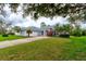 Inviting home with lush green lawn, mature landscaping, and a charming arched entryway at 2708 Turnbull Estates Dr, New Smyrna Beach, FL 32168