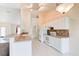 Galley kitchen featuring white appliances, tile backsplash, and breakfast bar seating at 2708 Turnbull Estates Dr, New Smyrna Beach, FL 32168