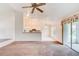 Living room with ceiling fan, kitchen view, and sliding glass doors to the screened porch at 2708 Turnbull Estates Dr, New Smyrna Beach, FL 32168