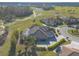 Idyllic aerial view of a home with a screened pool, lush landscaping, and a view of the golf course and pond at 2921 Linari Ct, New Smyrna Beach, FL 32168