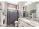 Bright bathroom with granite countertop, white cabinetry and a shower with a curtain at 2921 Linari Ct, New Smyrna Beach, FL 32168