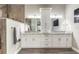 Bright bathroom features double sinks, granite countertops, white cabinetry, and a wood paneled wall at 2921 Linari Ct, New Smyrna Beach, FL 32168