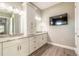 Bathroom showcasing double sinks, granite countertops, a television, and tiled floors at 2921 Linari Ct, New Smyrna Beach, FL 32168