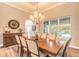 Elegant dining room with a large wooden table, stylish chandelier, and view of the pool through the window at 2921 Linari Ct, New Smyrna Beach, FL 32168