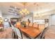 Open-concept dining area with a large table, elegant chandelier, and view into the living room and kitchen at 2921 Linari Ct, New Smyrna Beach, FL 32168