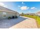 Exterior view of the driveway, manicured shrubbery and side of house under a blue sky at 2921 Linari Ct, New Smyrna Beach, FL 32168