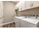 Bright laundry room featuring modern washer and dryer, a utility sink and white storage cabinets at 2921 Linari Ct, New Smyrna Beach, FL 32168