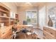 Bright home office with built-in bookshelves, wood desk, and a large window with plantation shutters at 2921 Linari Ct, New Smyrna Beach, FL 32168