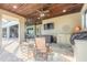 Covered patio with stone floors and wood ceiling features an outdoor kitchen and lounge seating at 2921 Linari Ct, New Smyrna Beach, FL 32168