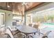 Covered patio with stone floors and wood ceiling features outdoor kitchen and adjacent screened pool at 2921 Linari Ct, New Smyrna Beach, FL 32168