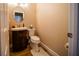 Cozy half-bathroom featuring wood-look floors, a vanity sink, and a toilet with a plush rug at 2995 Ragis Rd, Edgewater, FL 32132