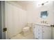 Bright bathroom with a marble countertop vanity, oval mirror, and shower with patterned curtain at 2995 Ragis Rd, Edgewater, FL 32132