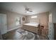 Spacious main bedroom featuring a ceiling fan, hardwood floors, and natural light from a large window at 2995 Ragis Rd, Edgewater, FL 32132