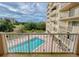 Balcony view of a pool and manicured greenery at 3 Oceans West Boulevard # 3B, Daytona Beach Shores, FL 32118