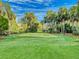 A lush green golf course under a blue sky with fluffy white clouds and thick trees at 3 Oceans West Boulevard # 3B1, Daytona Beach Shores, FL 32118