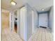 Hallway with white tiled floors, doors to bedrooms, and a front door entrance at 3 Oceans West Boulevard # 3B, Daytona Beach Shores, FL 32118