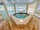 Indoor hot tub with tile surround and a view to the pool at 3 Oceans West Boulevard # 3B1, Daytona Beach Shores, FL 32118