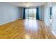 Bright living room with wood floors and a sliding glass door to the balcony at 3 Oceans West Boulevard # 3B, Daytona Beach Shores, FL 32118