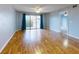 Bright living room with wood floors and a sliding glass door to the balcony at 3 Oceans West Boulevard # 3B1, Daytona Beach Shores, FL 32118