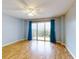 Bright living room with wood floors and a sliding glass door to the balcony at 3 Oceans West Boulevard # 3B1, Daytona Beach Shores, FL 32118