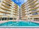 Exterior view of pool reflecting surrounding condo building with private balconies under blue skies at 3 Oceans West Boulevard # 3B, Daytona Beach Shores, FL 32118