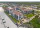 Beautiful aerial view of a multi-unit building with red tile roofs, lush lawn, and easy beach access at 3001 S Atlantic Ave # 204, New Smyrna Beach, FL 32169