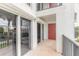 View of the home's balcony with sliding glass doors and a painted front door at 3001 S Atlantic Ave # 204, New Smyrna Beach, FL 32169