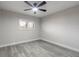 Neutral bedroom with modern ceiling fan, shuttered window and gray wood floors at 3001 S Atlantic Ave # 204, New Smyrna Beach, FL 32169