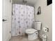 Full bathroom with a seashell-themed shower curtain, ceramic toilet and tile floor at 3047 S Atlantic Ave # B050, Daytona Beach, FL 32118