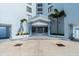 A condo complex entrance with palm trees, a covered entryway and a blue and white exterior at 3047 S Atlantic Ave # B050, Daytona Beach, FL 32118