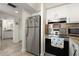 This Kitchen features stainless steel appliances and granite countertops, next to the entrance of the bathroom at 3047 S Atlantic Ave # B050, Daytona Beach, FL 32118